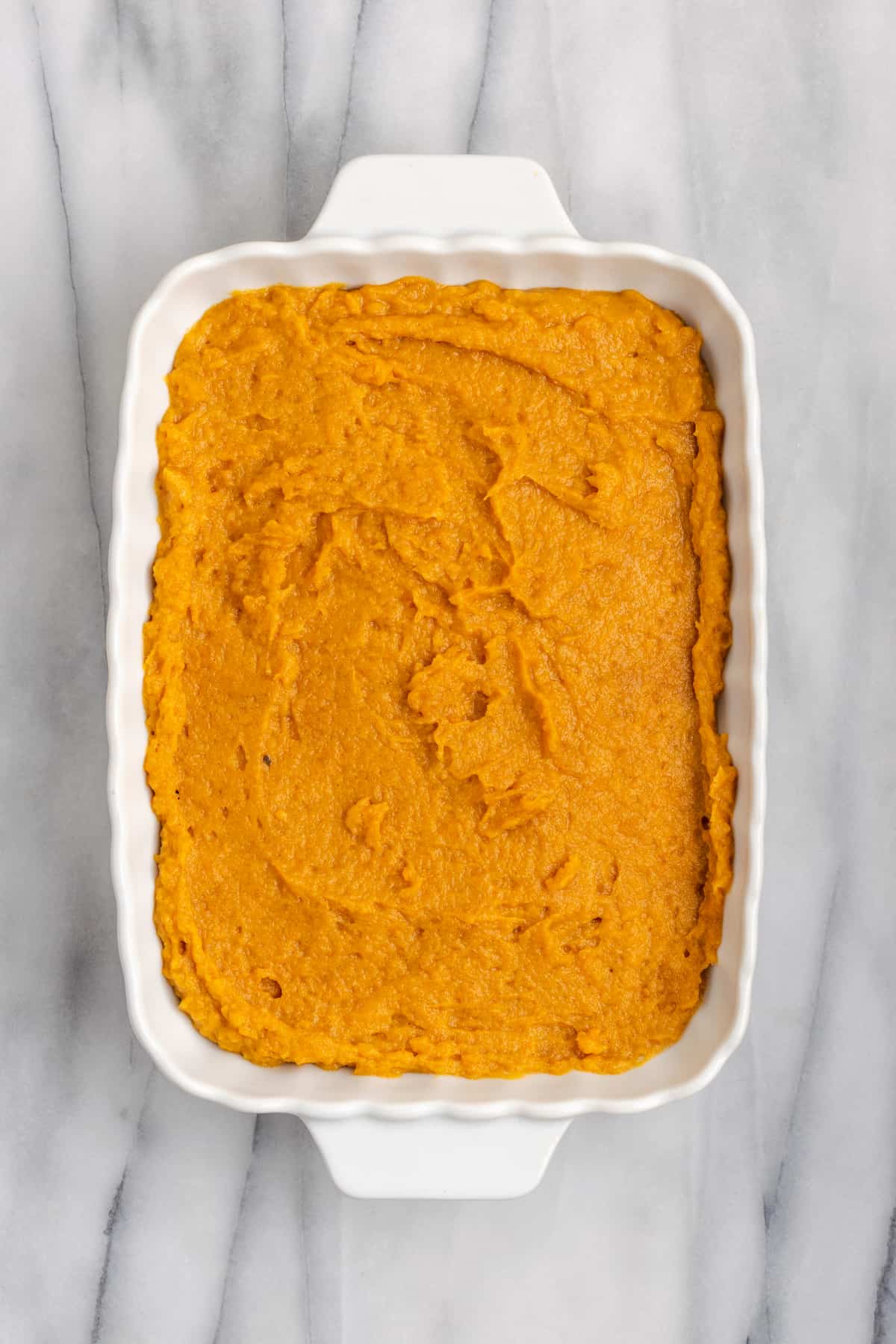 Overhead view of uncooked sweet potato soufflé in a casserole dish