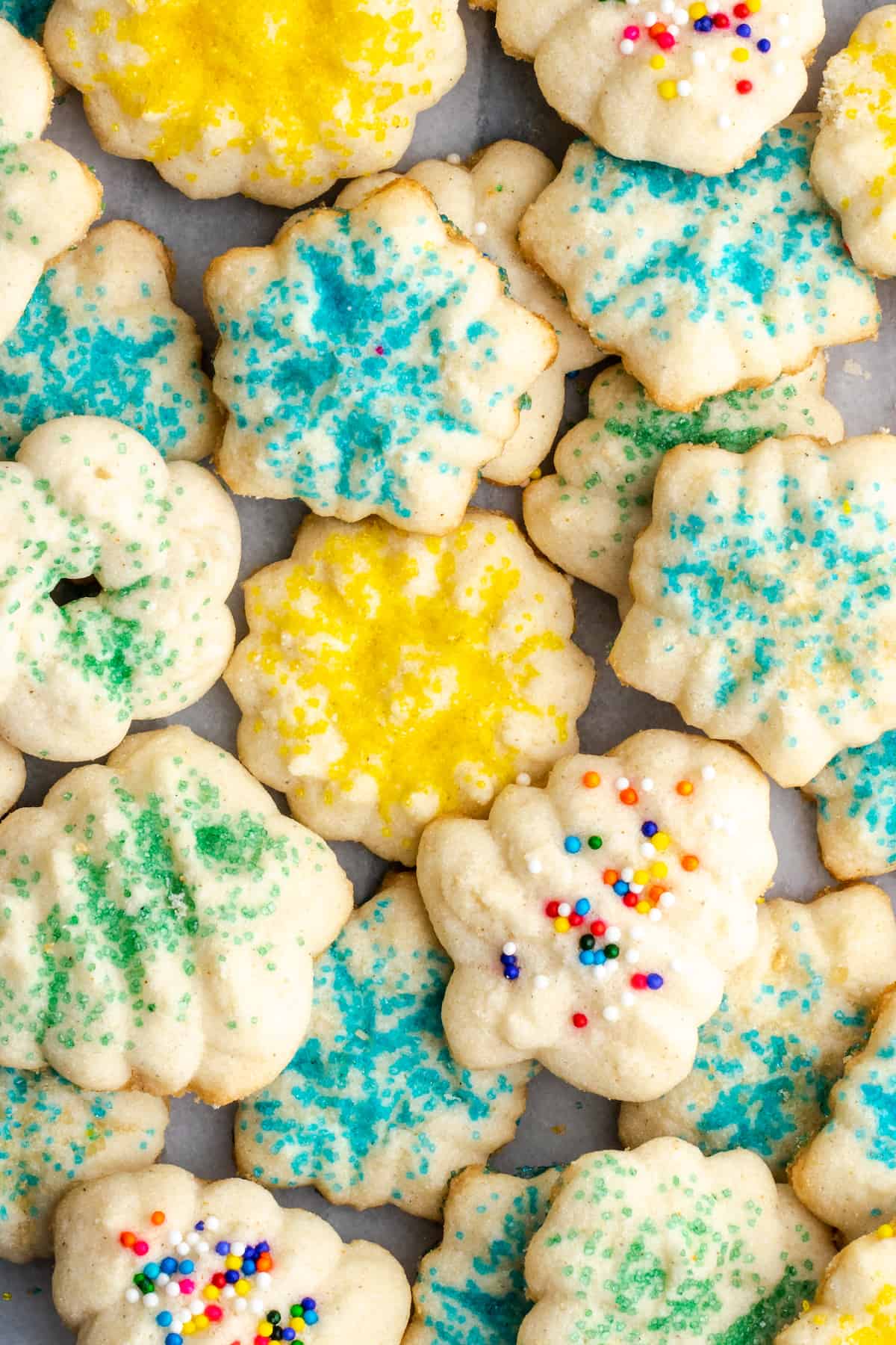 Overhead view of a pile of spritz cookies covered in different colors of sprinkles