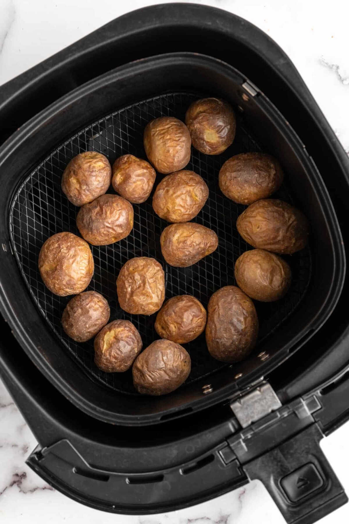 Cooked baby potatoes in an air fryer basket