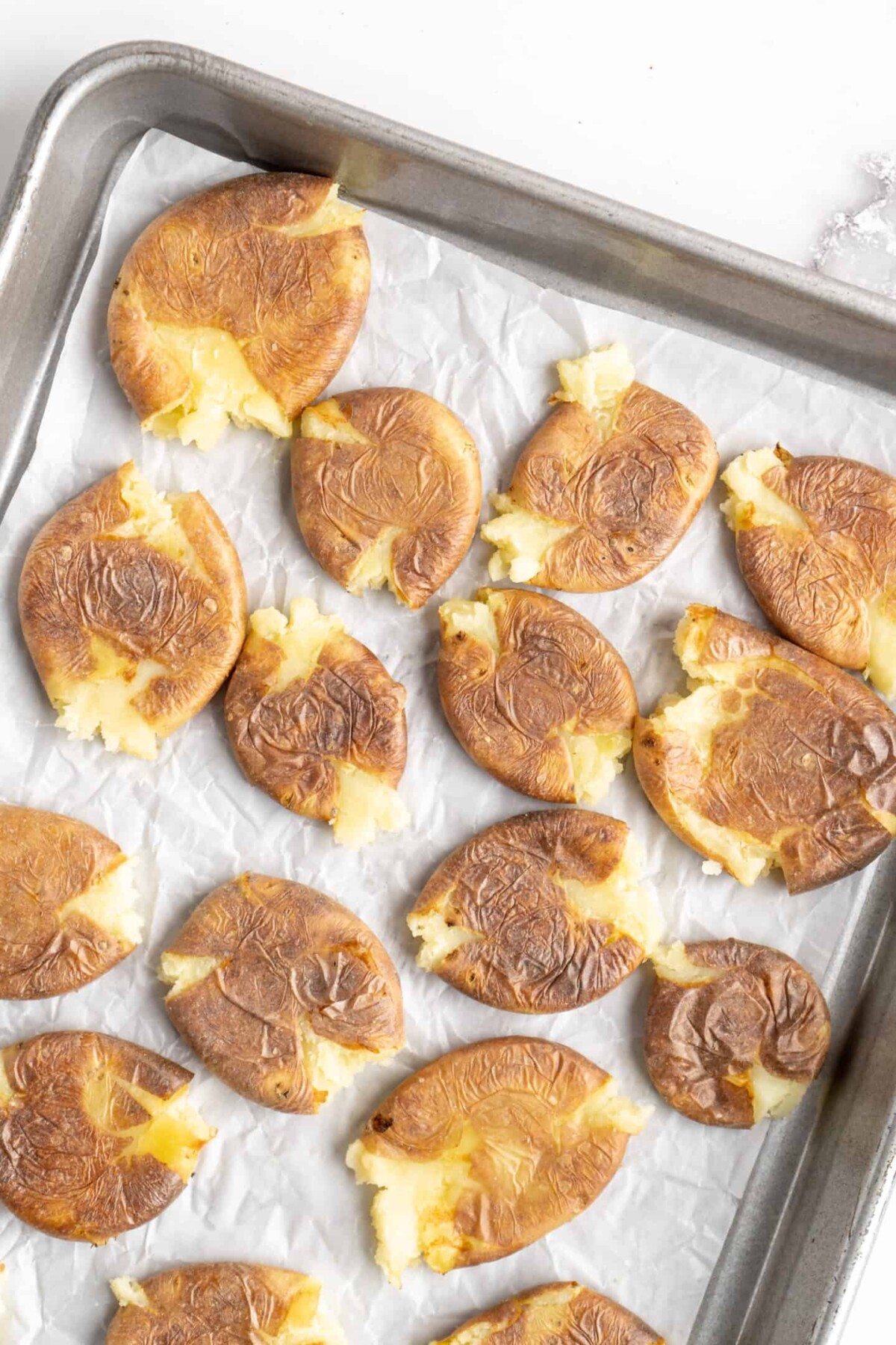 A baking sheet full of smashed potatoes