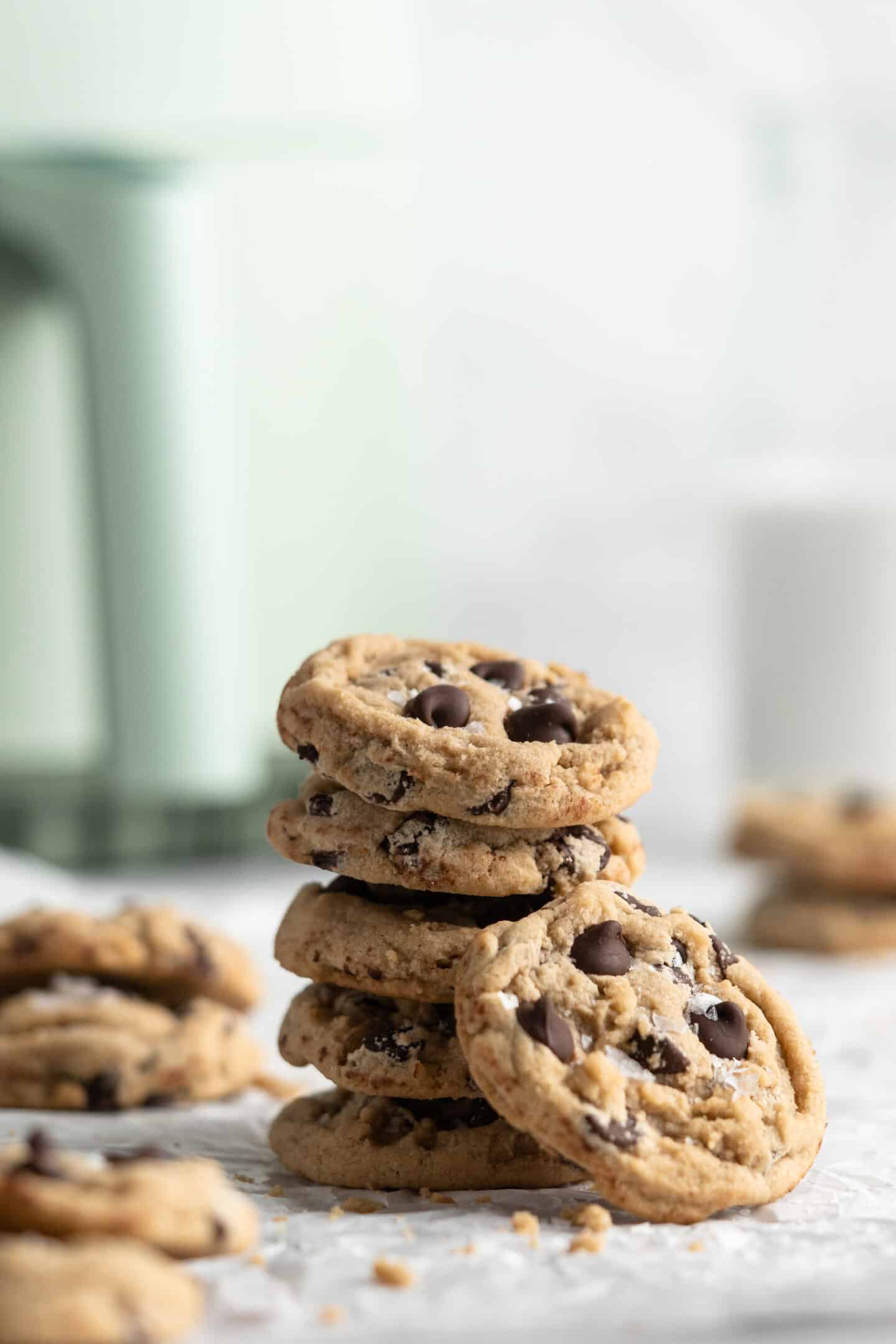 Stack of vegan chocolate chip cookies with pitcher of milk and air fryer in background