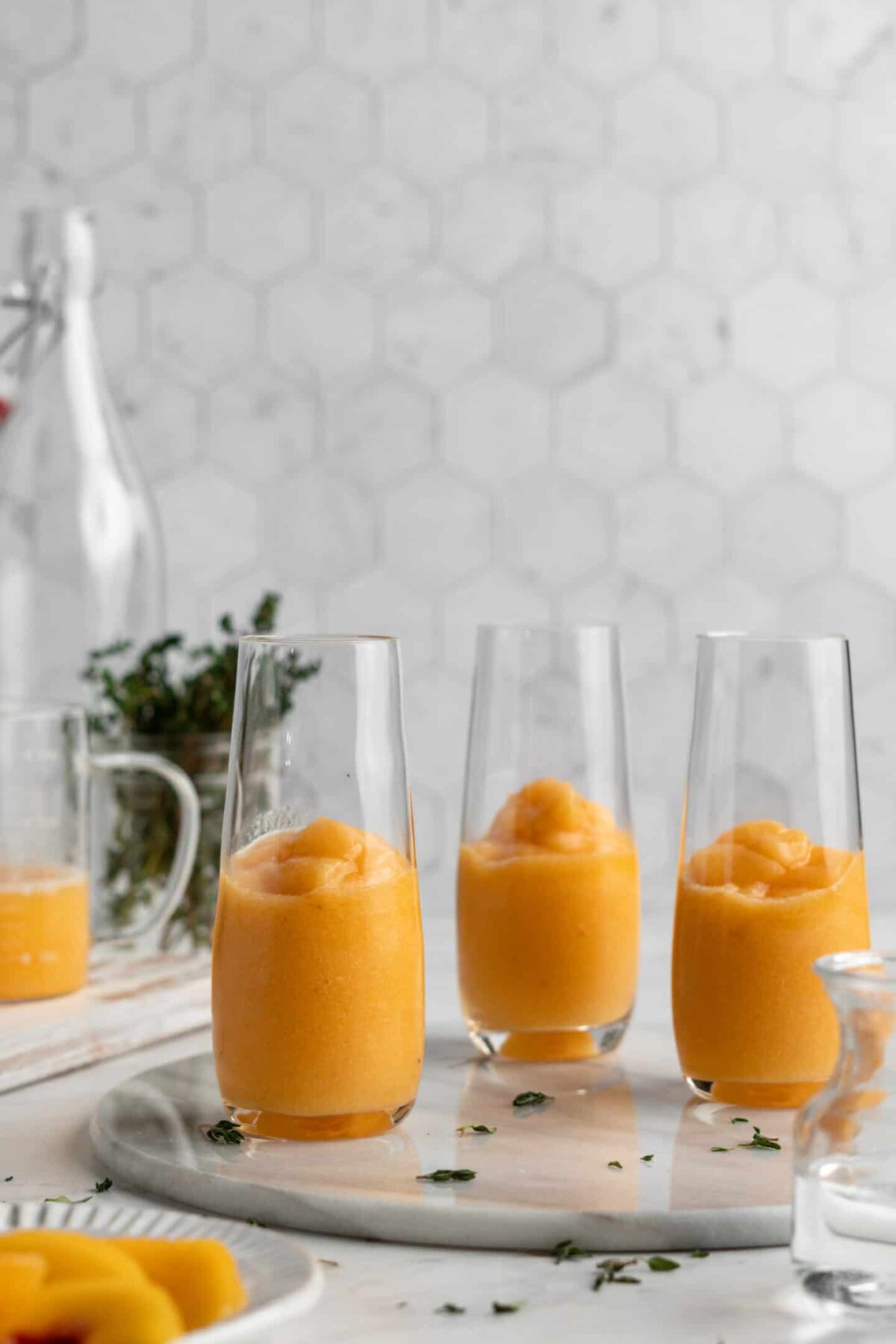 Three tall glasses filled halfway with peach puree