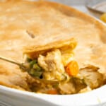 Close up of a spoonful of pot pie with a pot pie casserole in the background