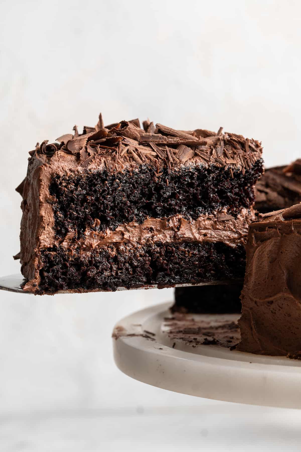 Removing slice of vegan chocolate cake from cake stand