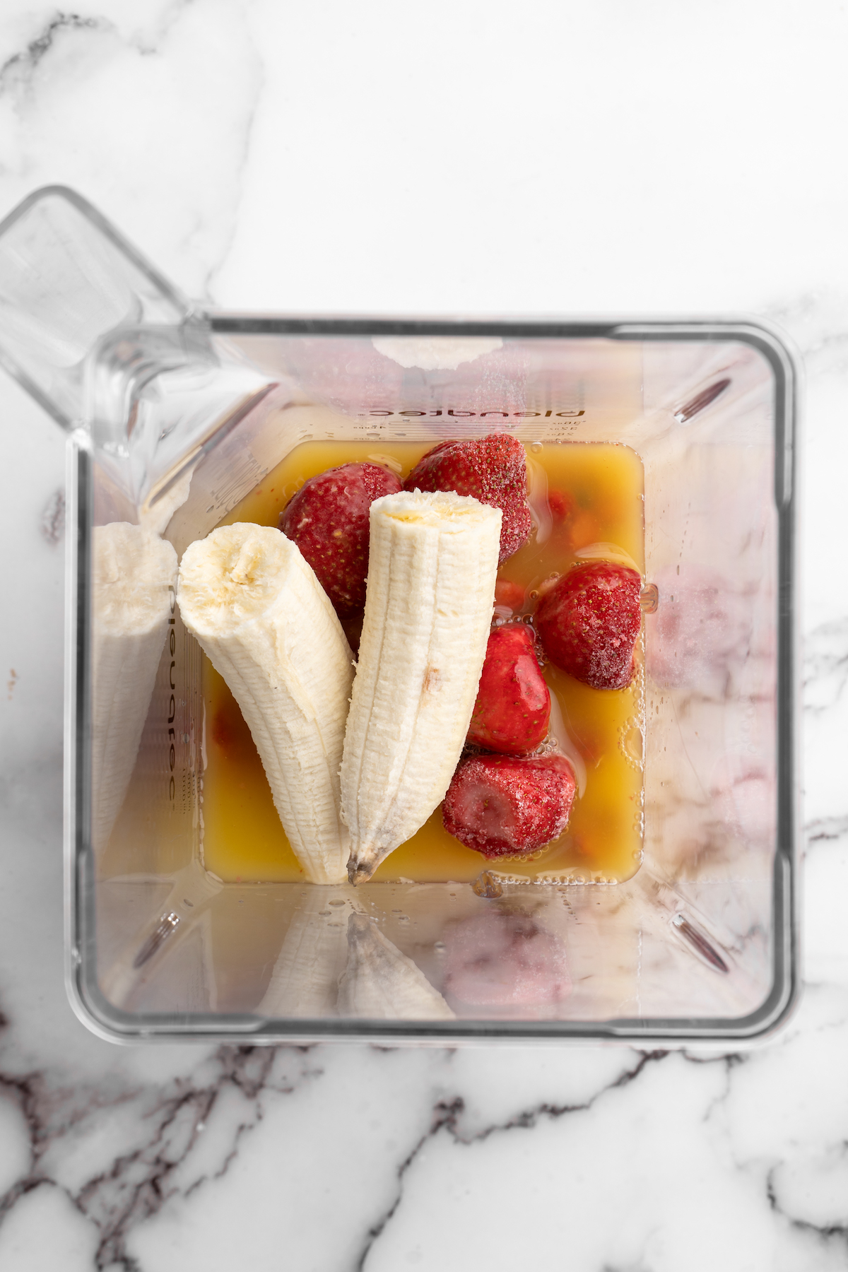 Overhead view of strawberry banana smoothie ingredients in blender