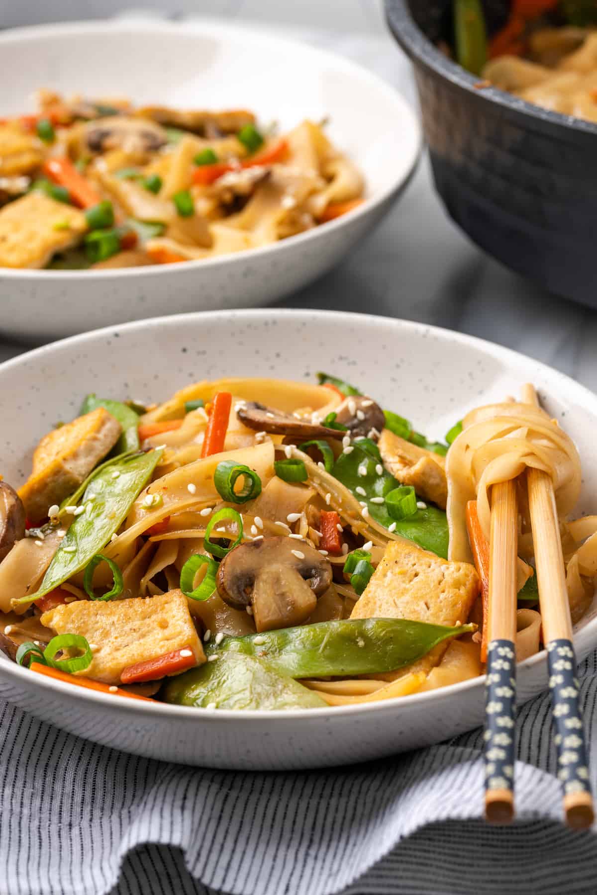 Bowl of vegan chow fun noodles with chopsticks