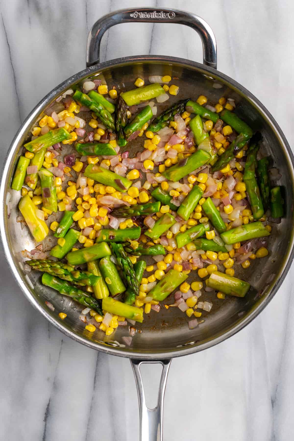 Corn, onions, and asparagus in skillet