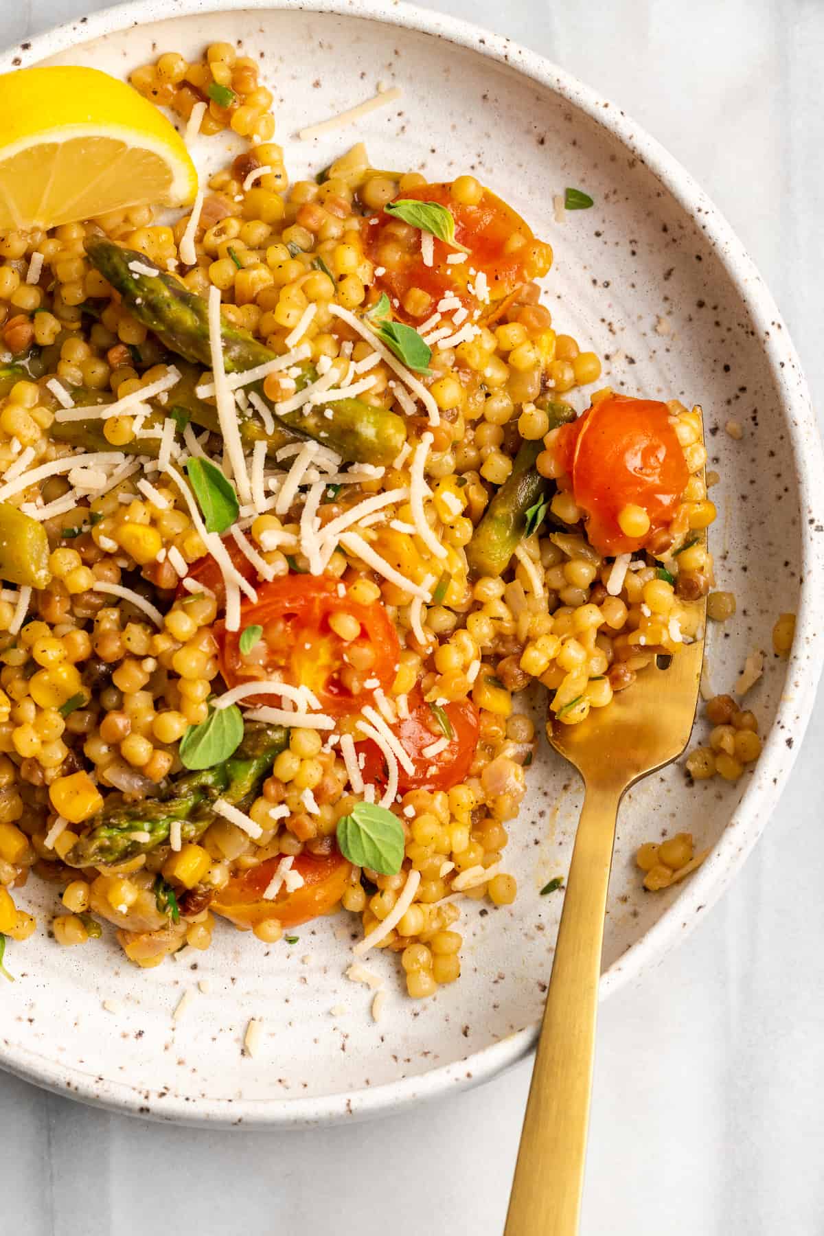 Overhead view of vegan fregola on plate with fork