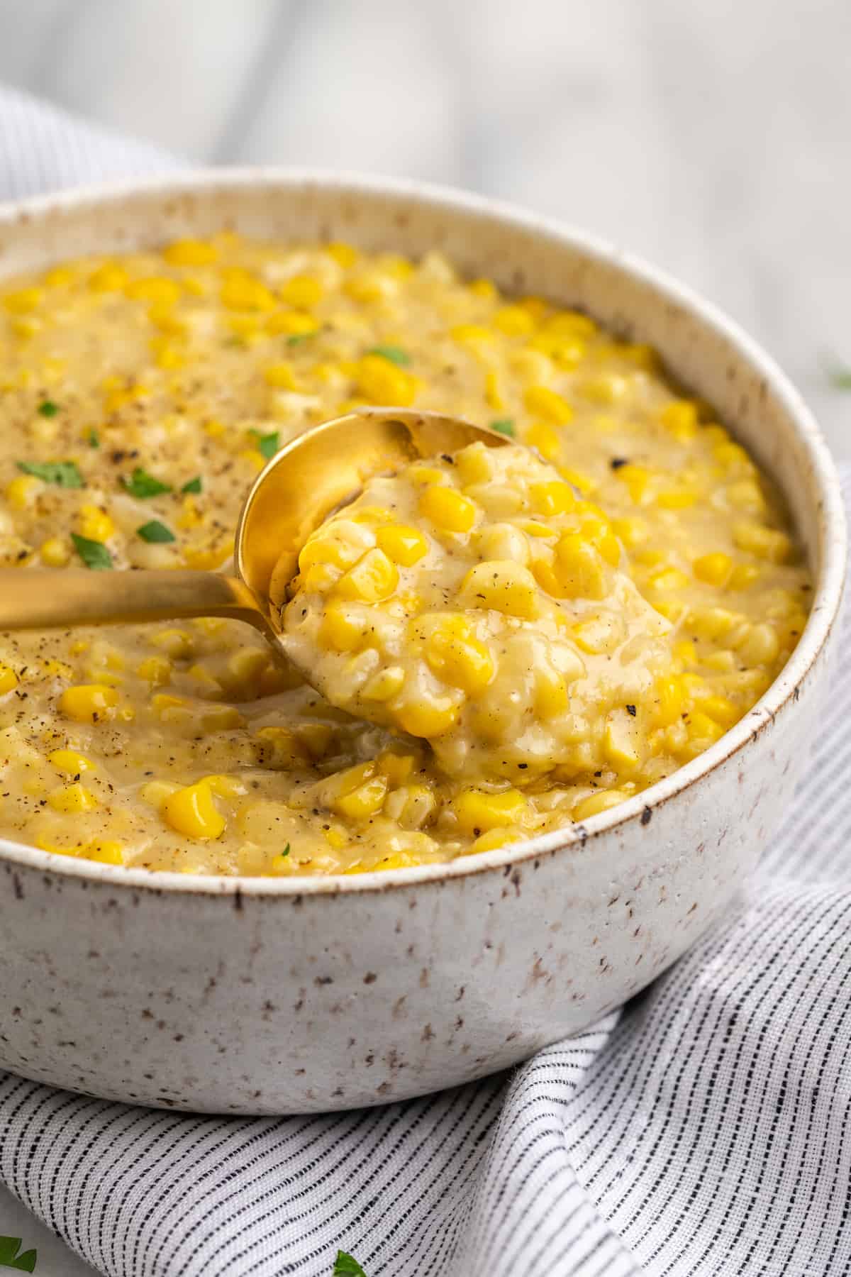 Spoon lifting vegan creamed corn from bowl