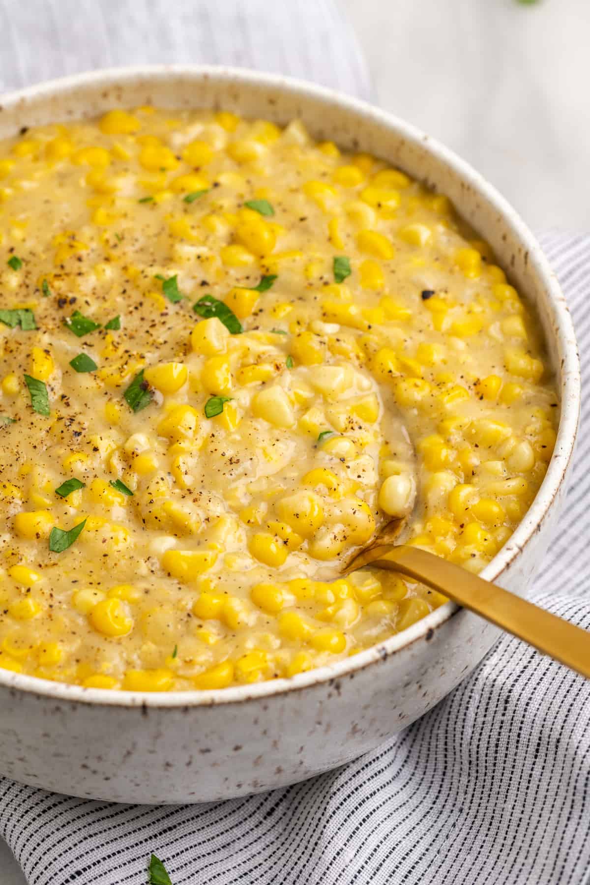 Vegan creamed corn in serving bowl with spoon