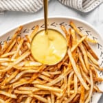 Overhead view of shoestring fries on plate with dipping sauce