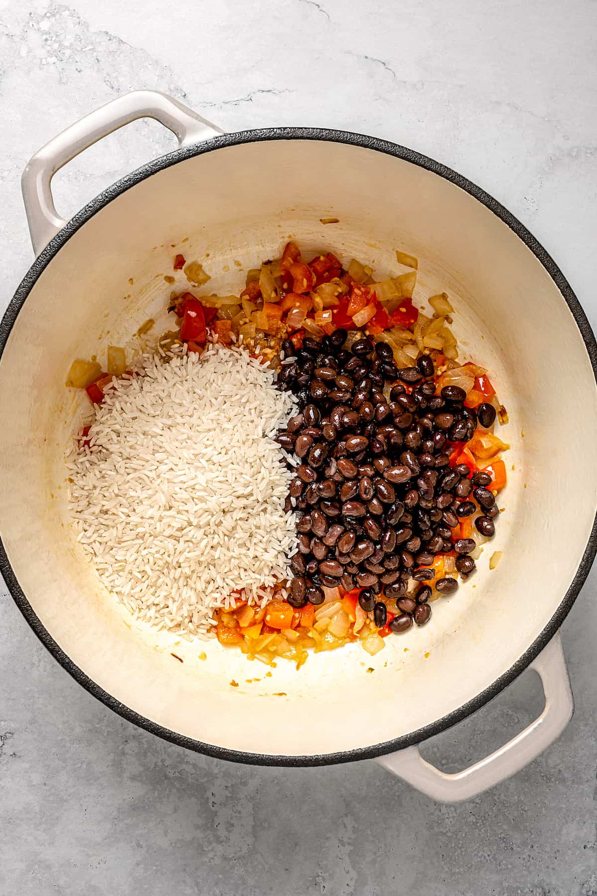 Adding rice and black beans to pot