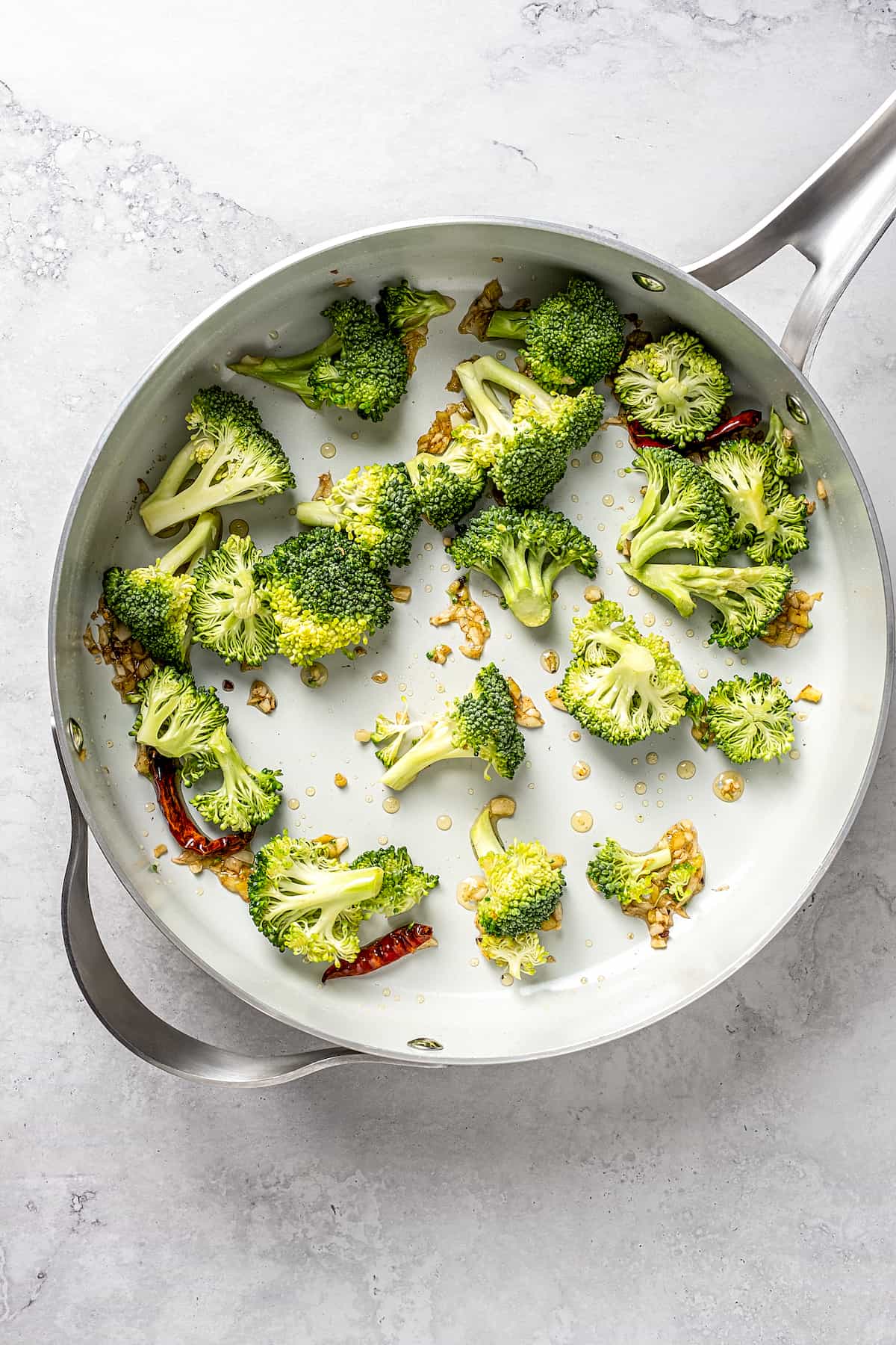 Overhead view of broccoli and garlic in skillet