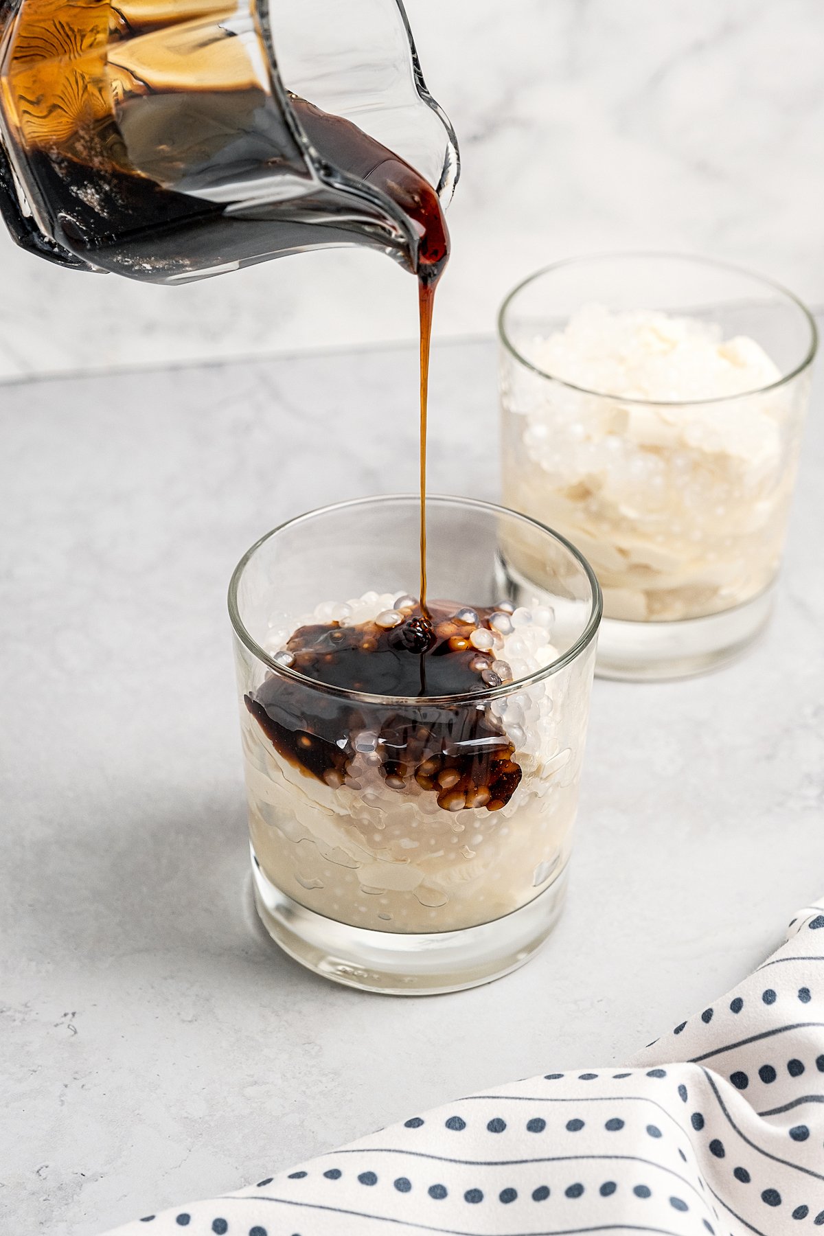 Pouring syrup into glass with tofu and sago