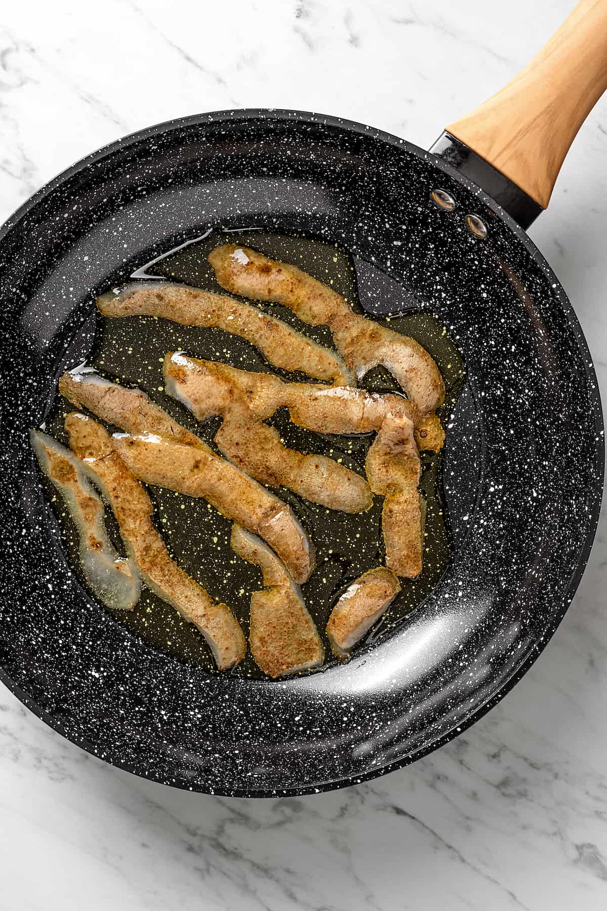 Overhead view of frying potato skins in skillet