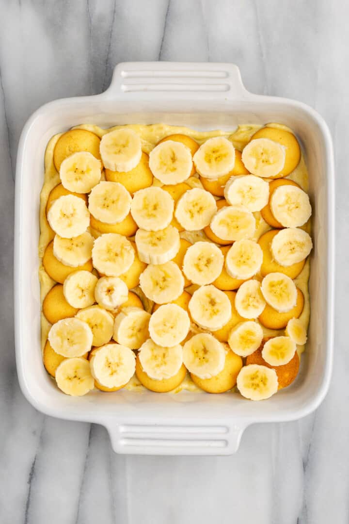 Layer of bananas and vanilla wafers in baking dish for banana pudding