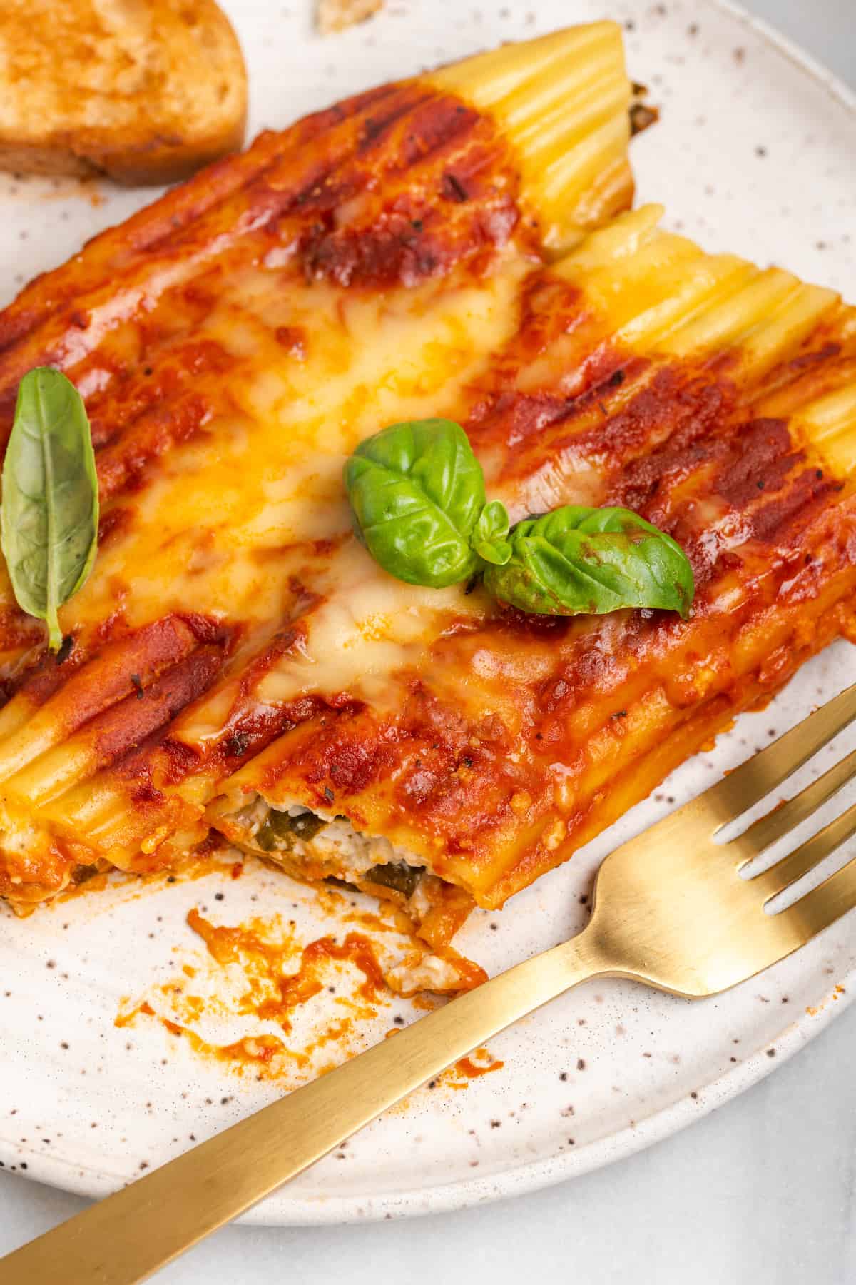 Vegan manicotti on plate with bite removed