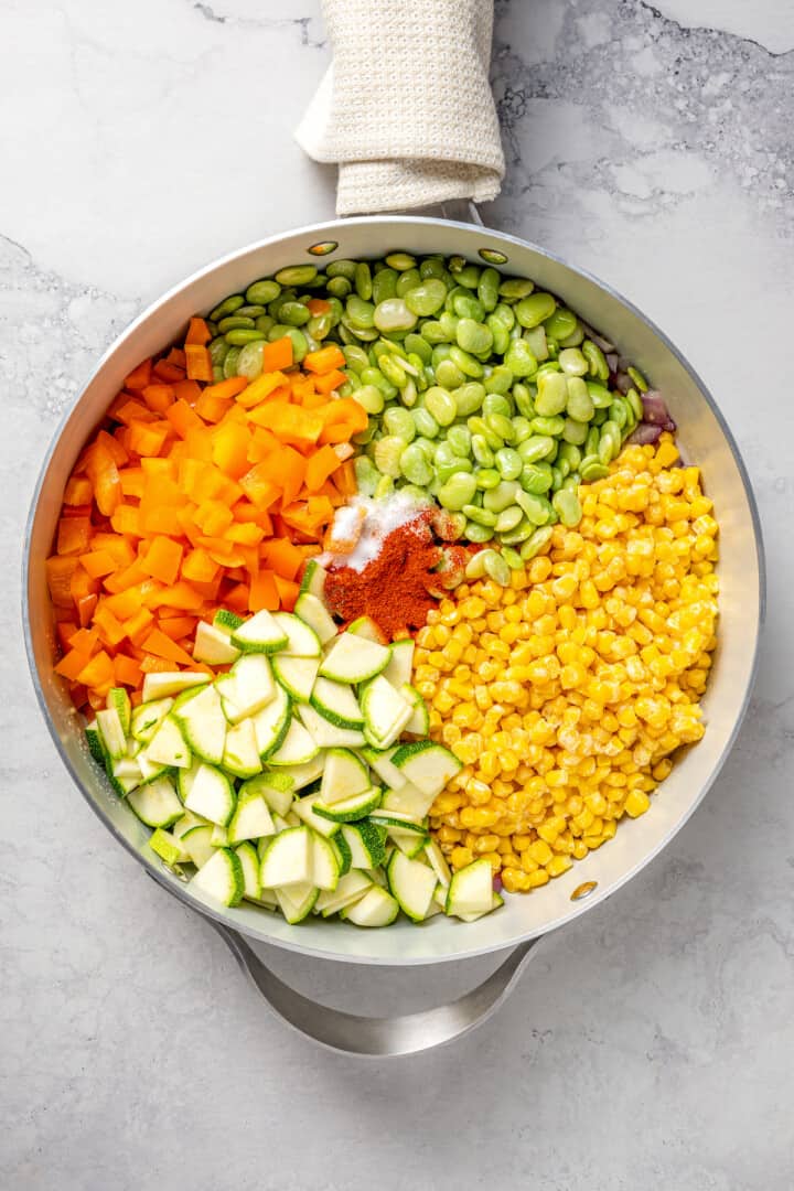 Overhead view of ingredients for corn succotash in skillet