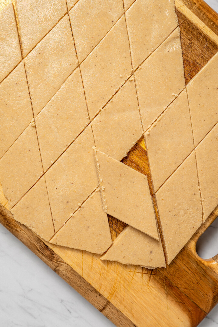 Kaju katli on wooden cutting board, cut into diamond-shaped pieces