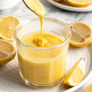 Spoon drizzling vegan lemon curd back into jar