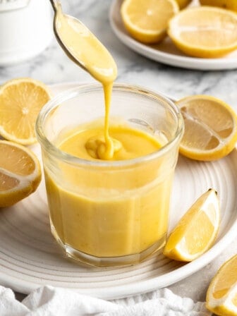 Spoon drizzling vegan lemon curd aid into jar  Hershey???s Cake Kisses Vegan Lemon Curd0350 336x448