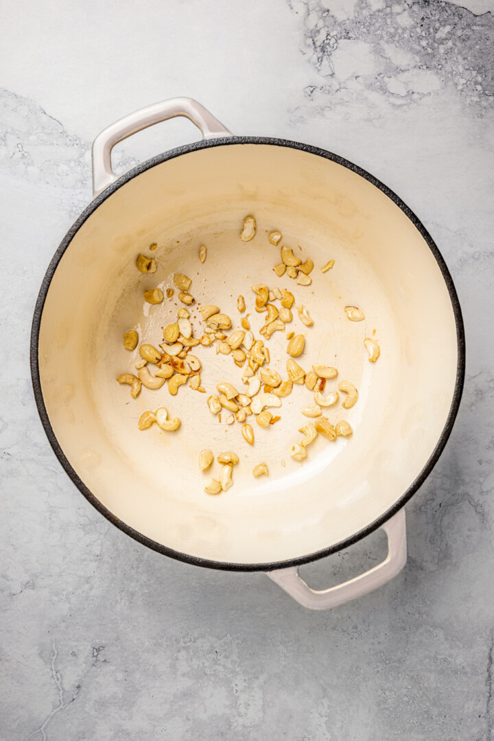 Overhead view of cashews toasting in pot