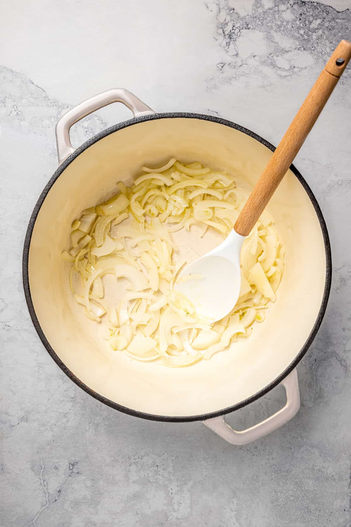 Overhead view of onions and spoon in pot