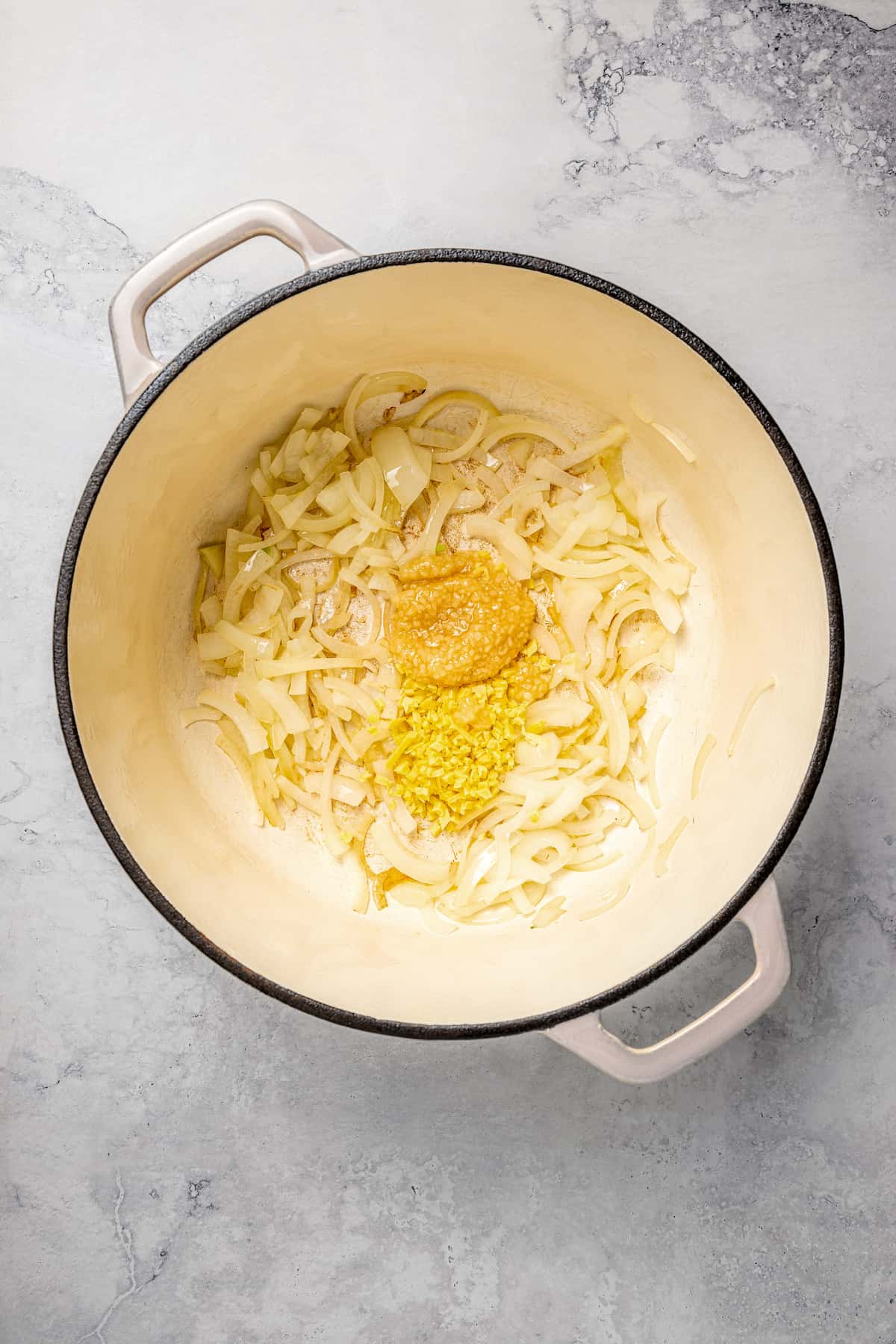 Overhead view of onions, ginger, and garlic in pot