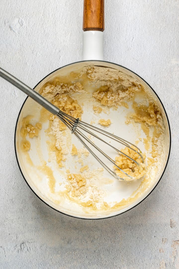 Overhead view of flour and butter in pan with whisk
