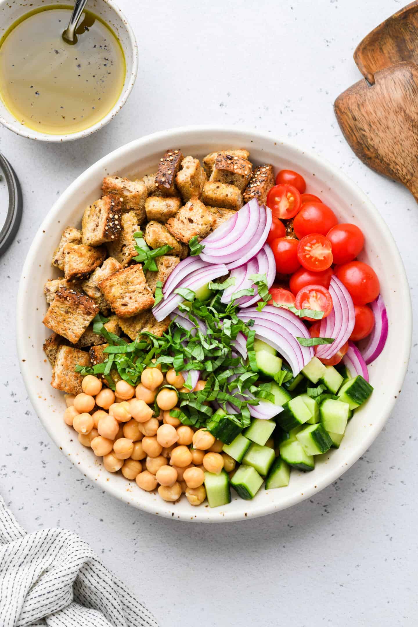 Chickpea panzanella salad in glass mixing bowl