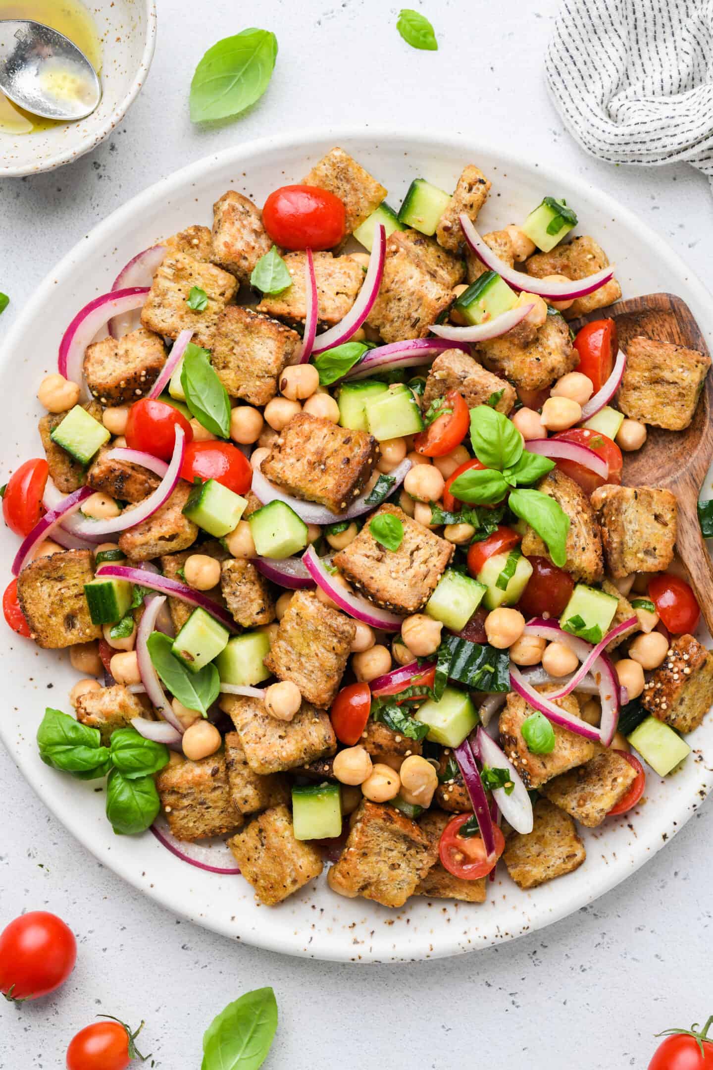 Overhead view of chickpea panzanella salad on white serving platter