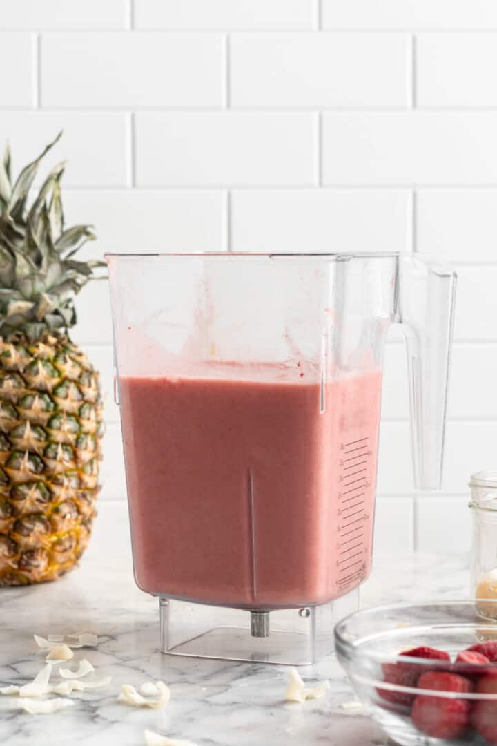 Strawberry pineapple smoothie in blender jar