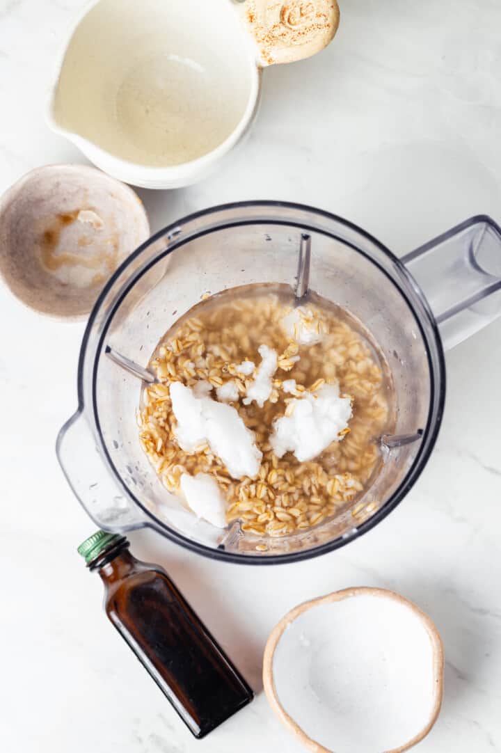 Overhead view of ingredients for oat milk coffee creamer in blender jar