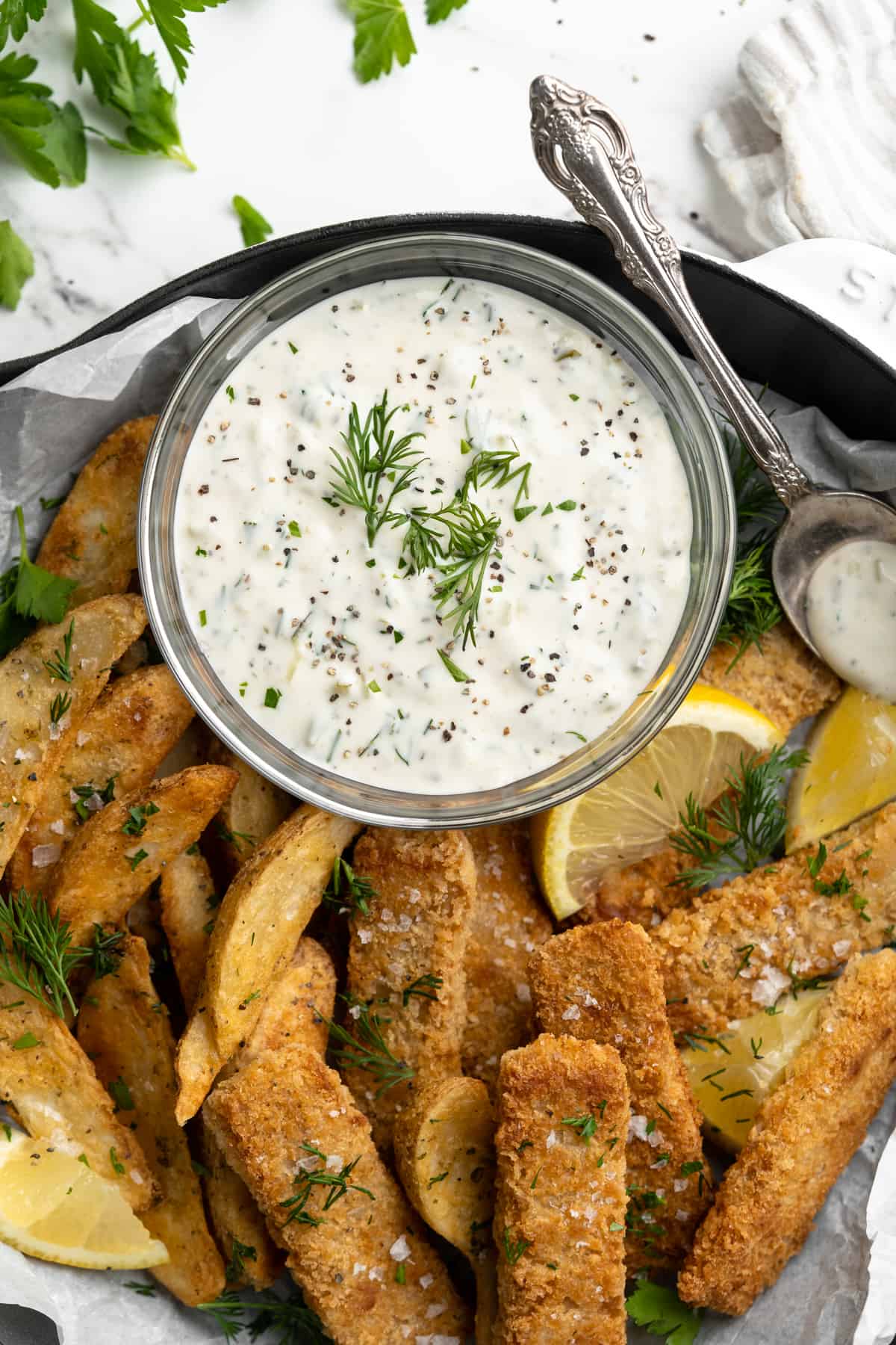Overhead view of vegan tartar sauce in bowl with vegan fish and chips
