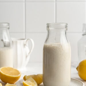 Jar of vegan buttermilk on plate with lemons