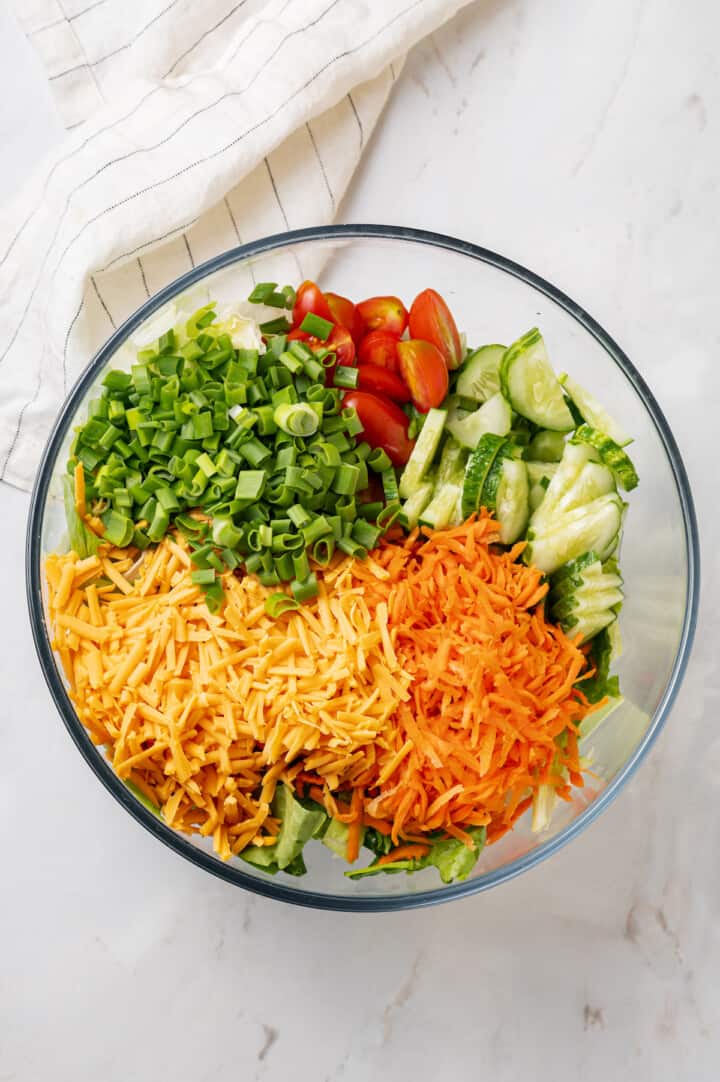 Overhead view of ingredients for vegan Chik-Fil-A cobb salad in glass bowl