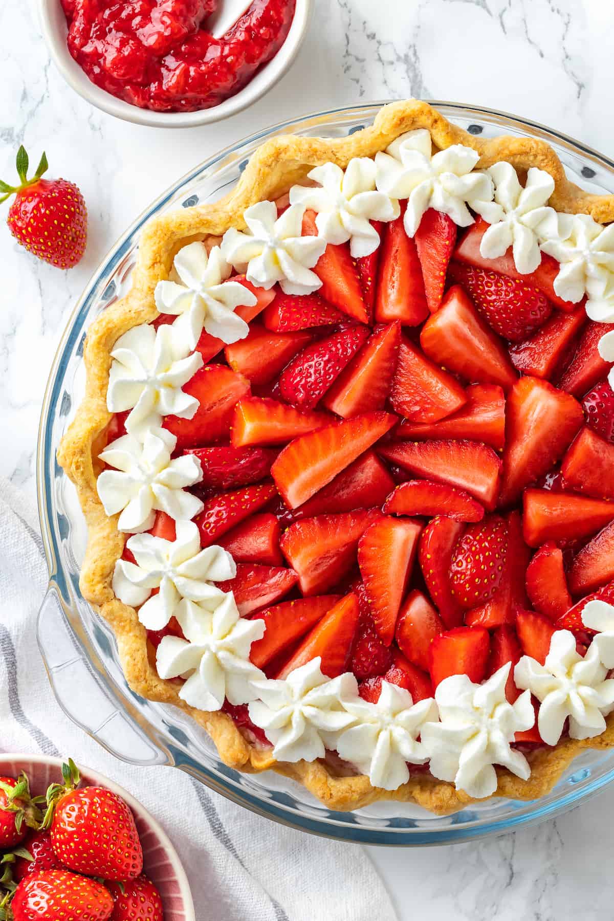 Fluffy, cool vegan strawberry cream pie is the perfect summer treat. It's a no-bake dessert packed with real strawberries in a creamy filling. Overhead view of strawberry cream pie in glass pie pan
