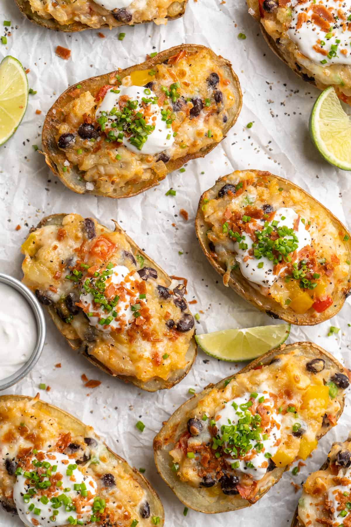 Overhead view of healthy loaded potato skins on parchment-lined baking sheet