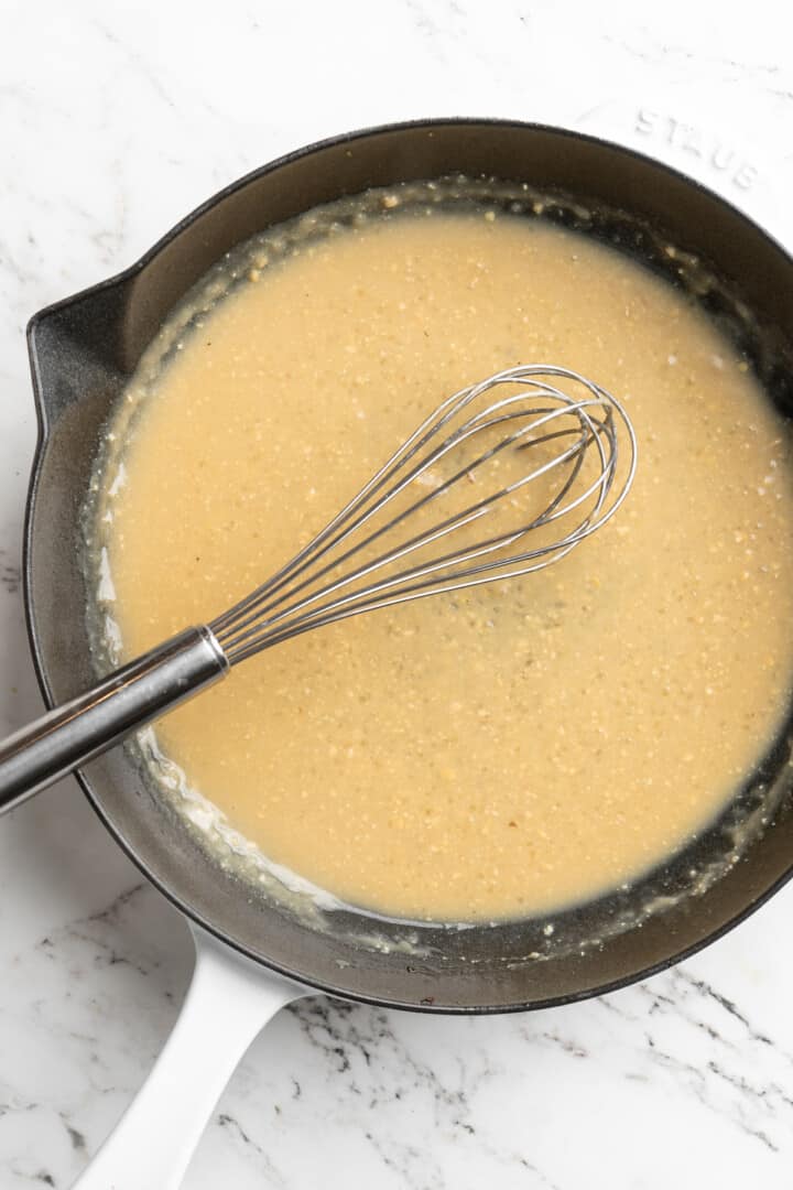 Overhead view of whisk in skillet of miso butter sauce