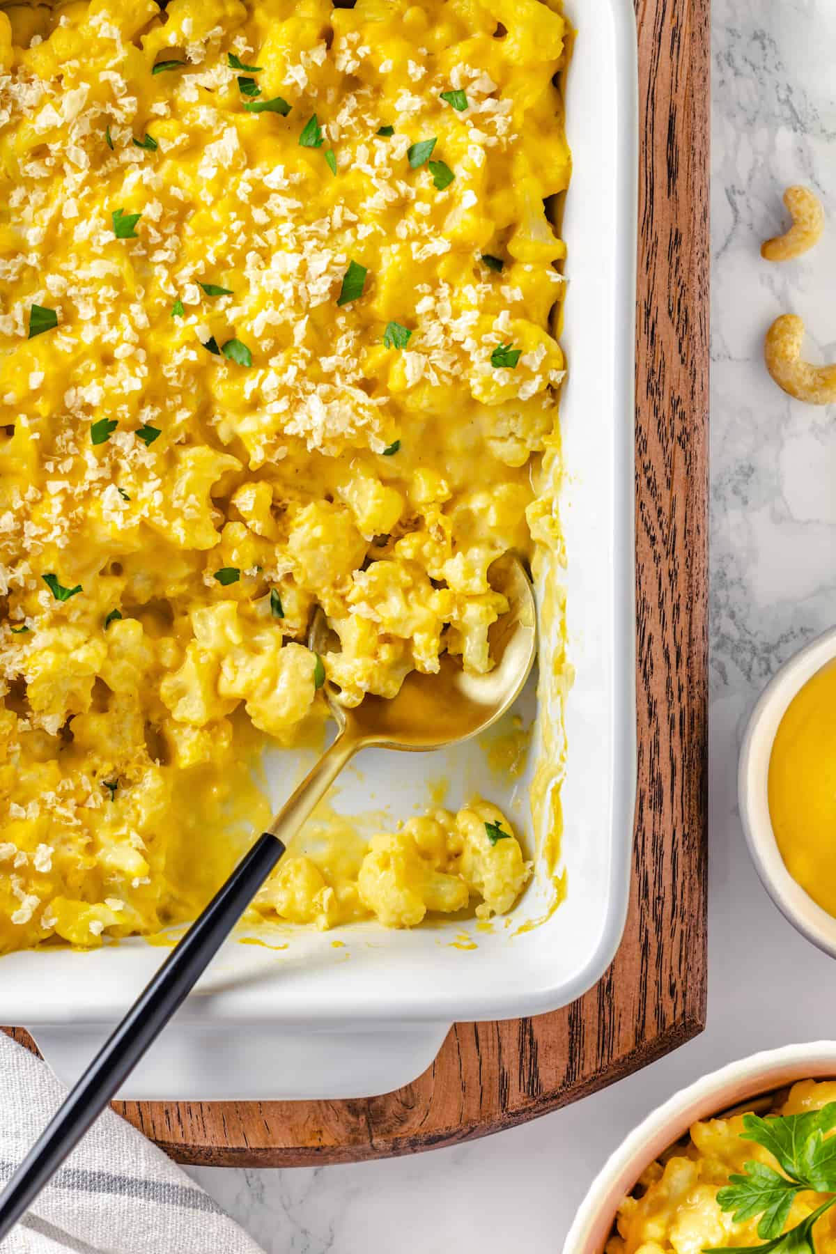 Overhead view of cauliflower mac and cheese in baking dish with spoon