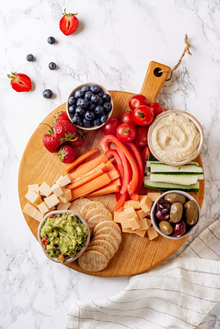 Overhead view of bowls and large ingredients set on round wooden board