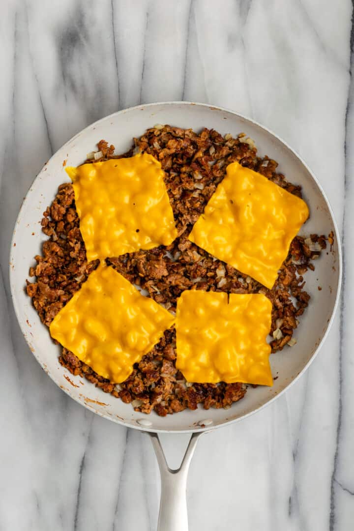 Melting cheese on top of vegan beef in a skillet