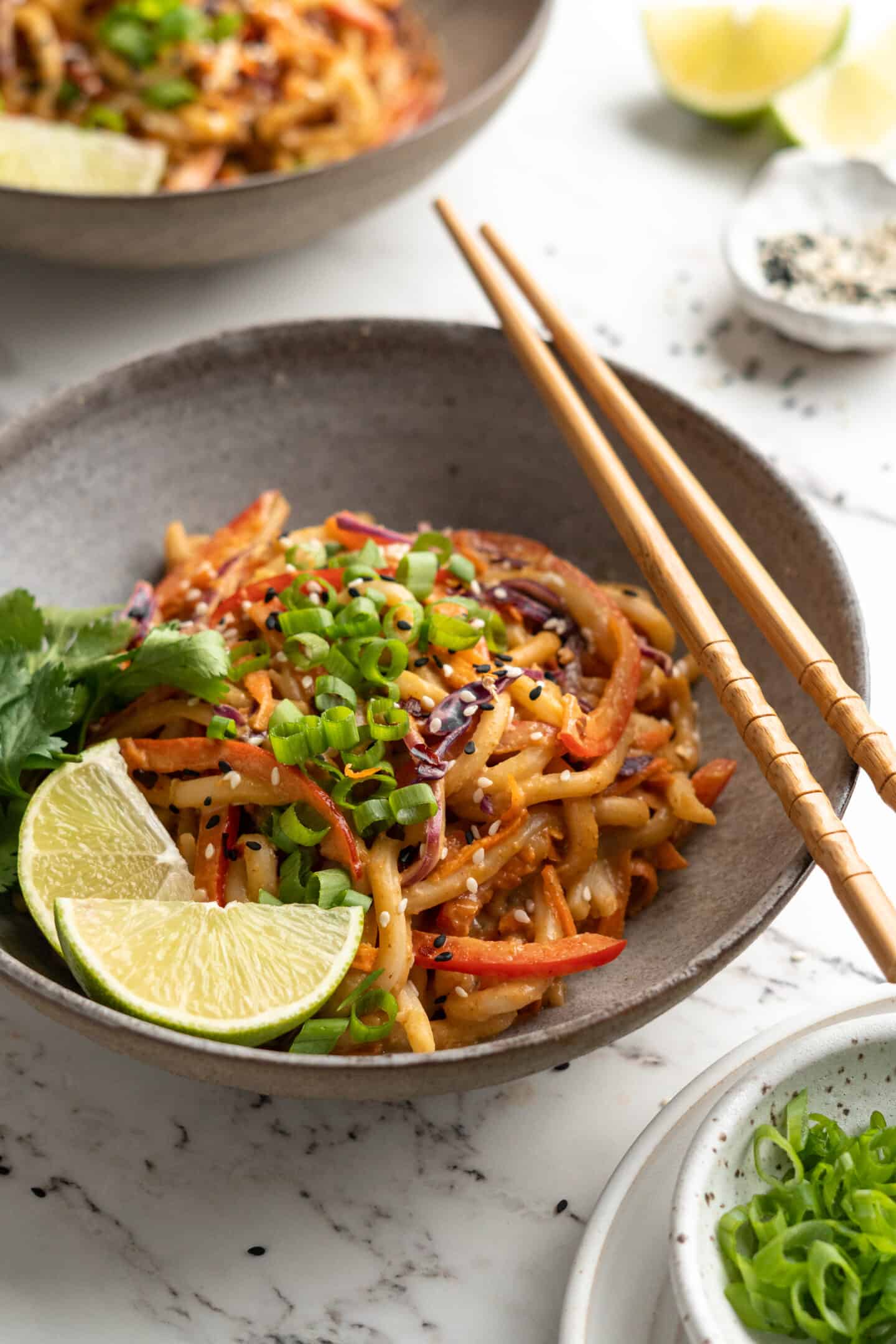 Bowl of Thai peanut noodles with chopsticks laid over top