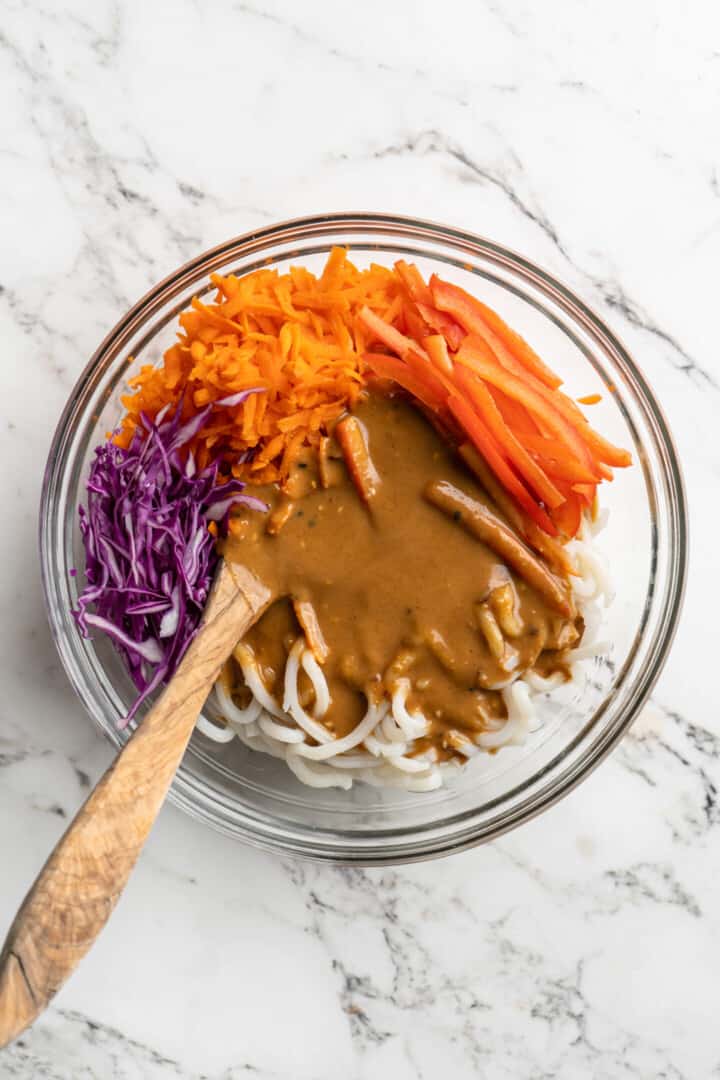 Overhead view of ingredients for Thai peanut noodles in mixing bowl before stirring