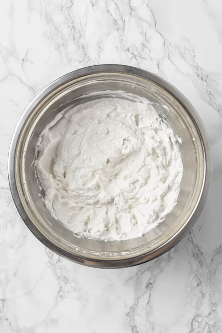 Overhead view of whipped coconut cream in mixing bowl