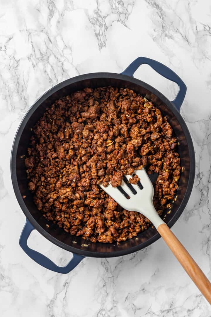 Overhead view of vegan ground beef in skillet with spatula