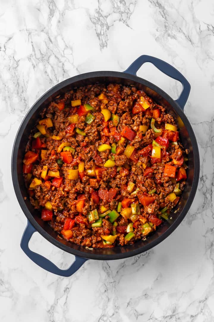 Overhead view of vegetables and vegan ground beef in skillet