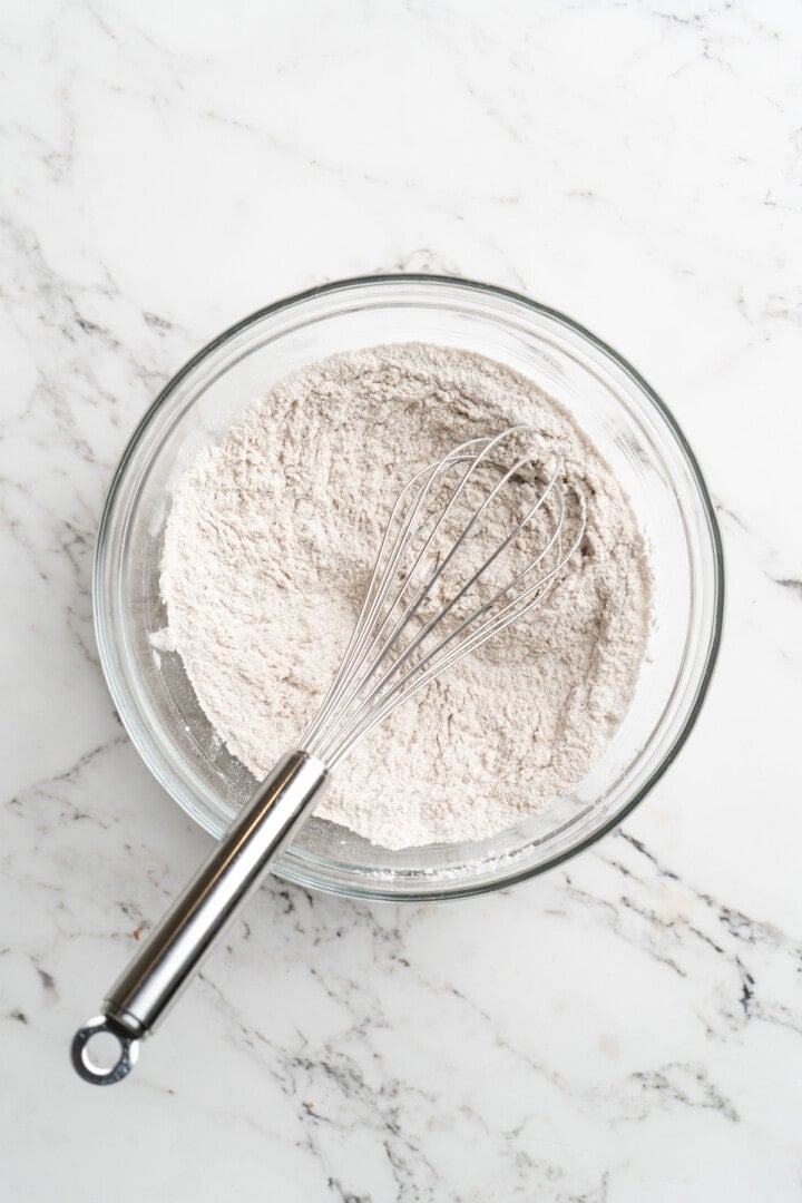 Overhead view of dry ingredients in mixing bowl with whisk