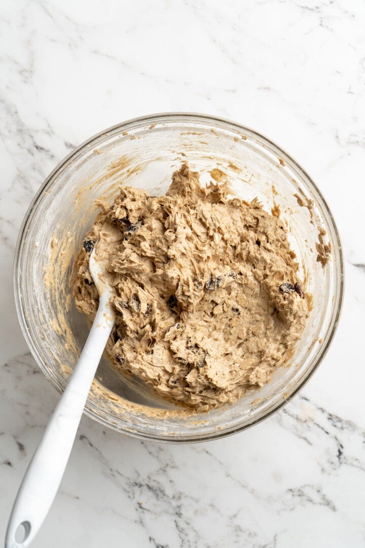 Overhead view of oatmeal raisin cookie dough in glass mixing bowl