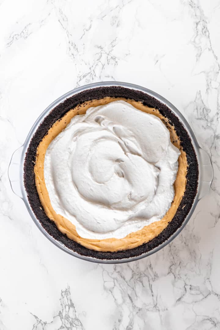 Overhead view of peanut butter pie after adding whipped cream